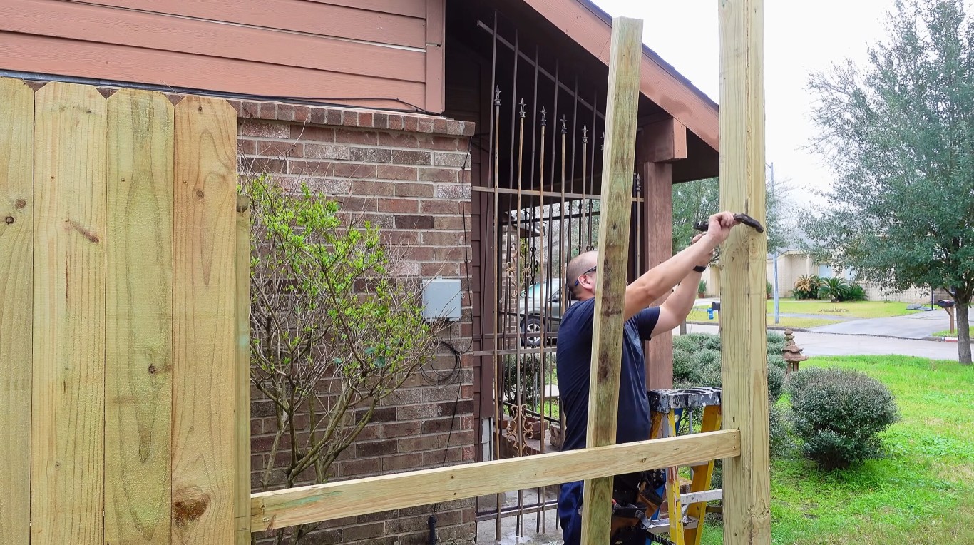 Professional fence installation crew working on residential fence in Tulare, CA